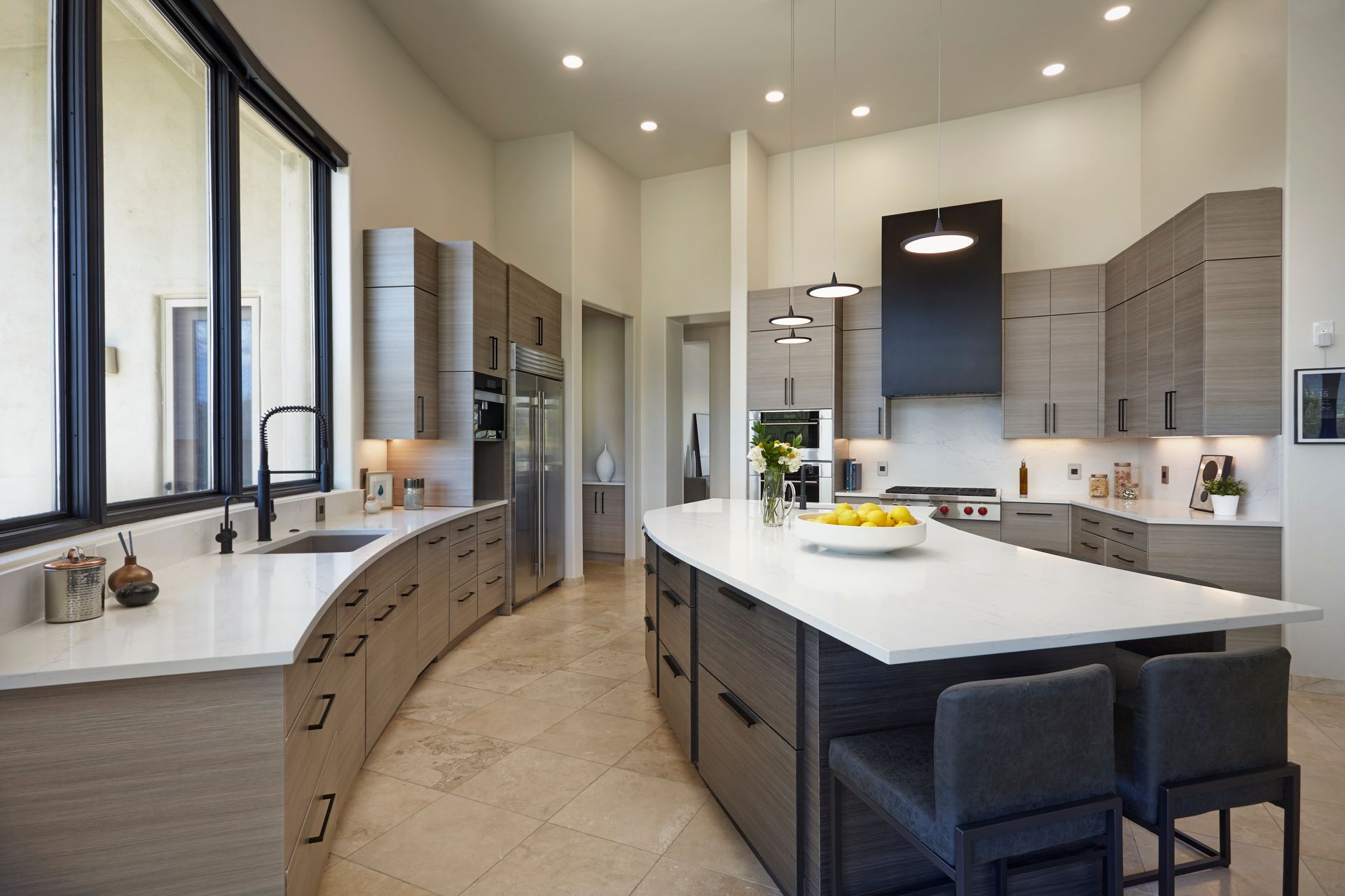 Modern kitchen with curved cabinets, large island, and stainless steel appliances.