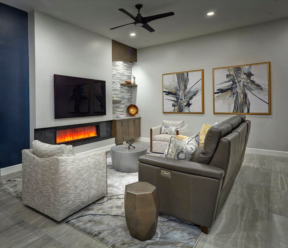 A living room with a fireplace , couch , chair and television.