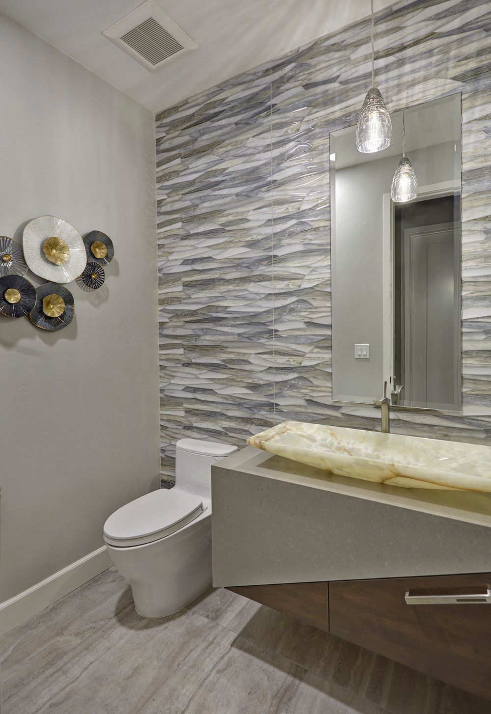 Modern powder room with textured wall, floating sink, and decorative wall art.