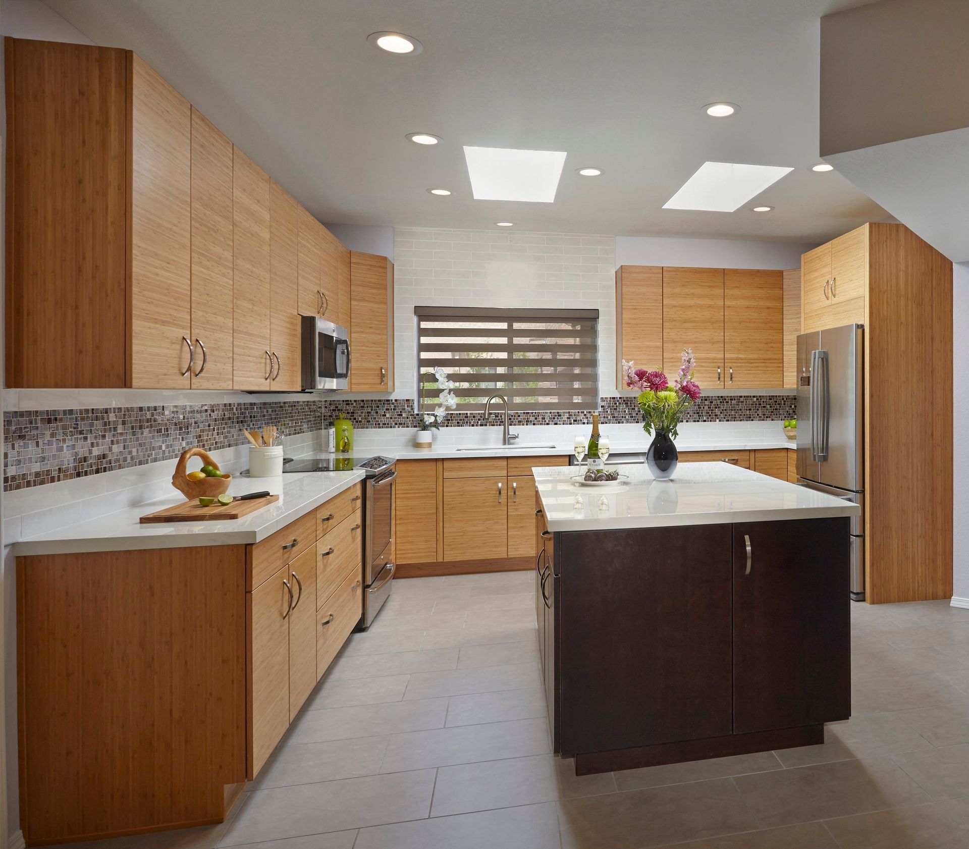 Modern kitchen with light wood cabinets, white countertops, and an island.