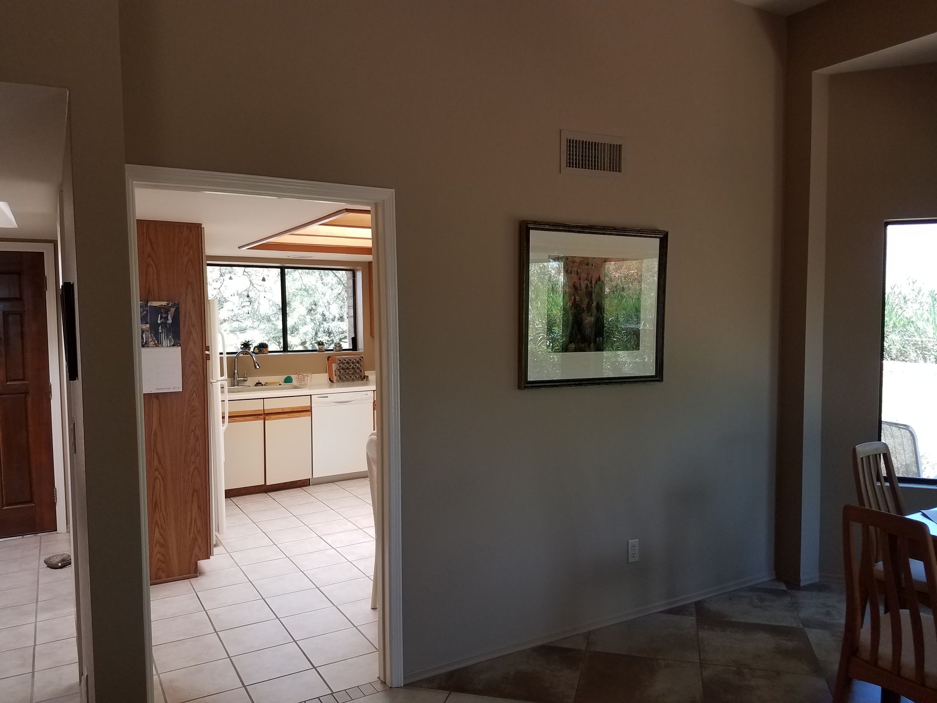 A kitchen and dining room are connected by a doorway