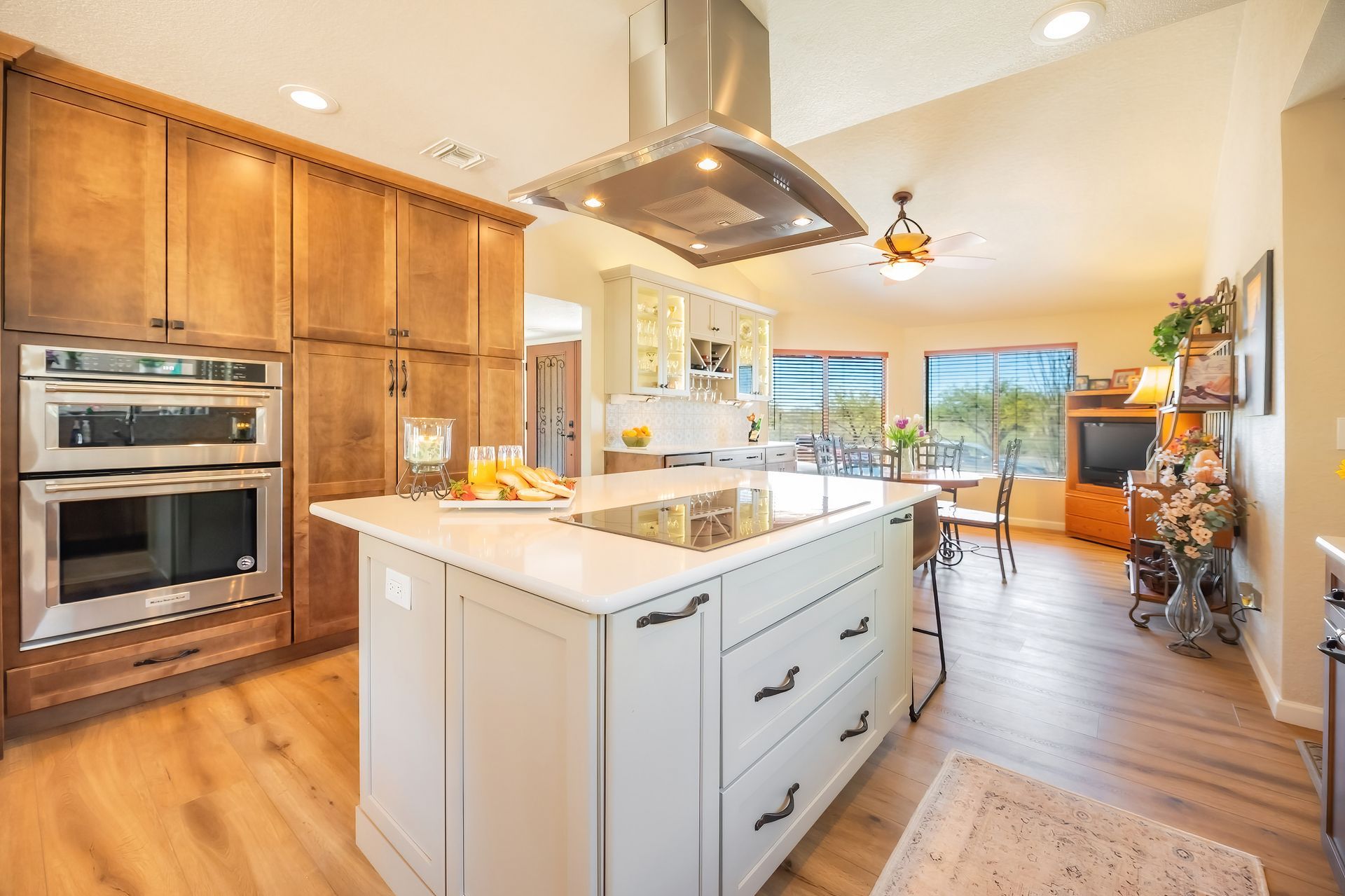 Kitchen with a white island, wooden cabinets, stainless steel appliances, and a dining area.