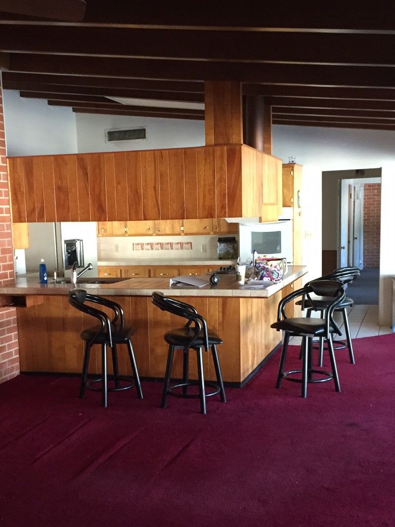 A kitchen with wooden cabinets and a red carpet