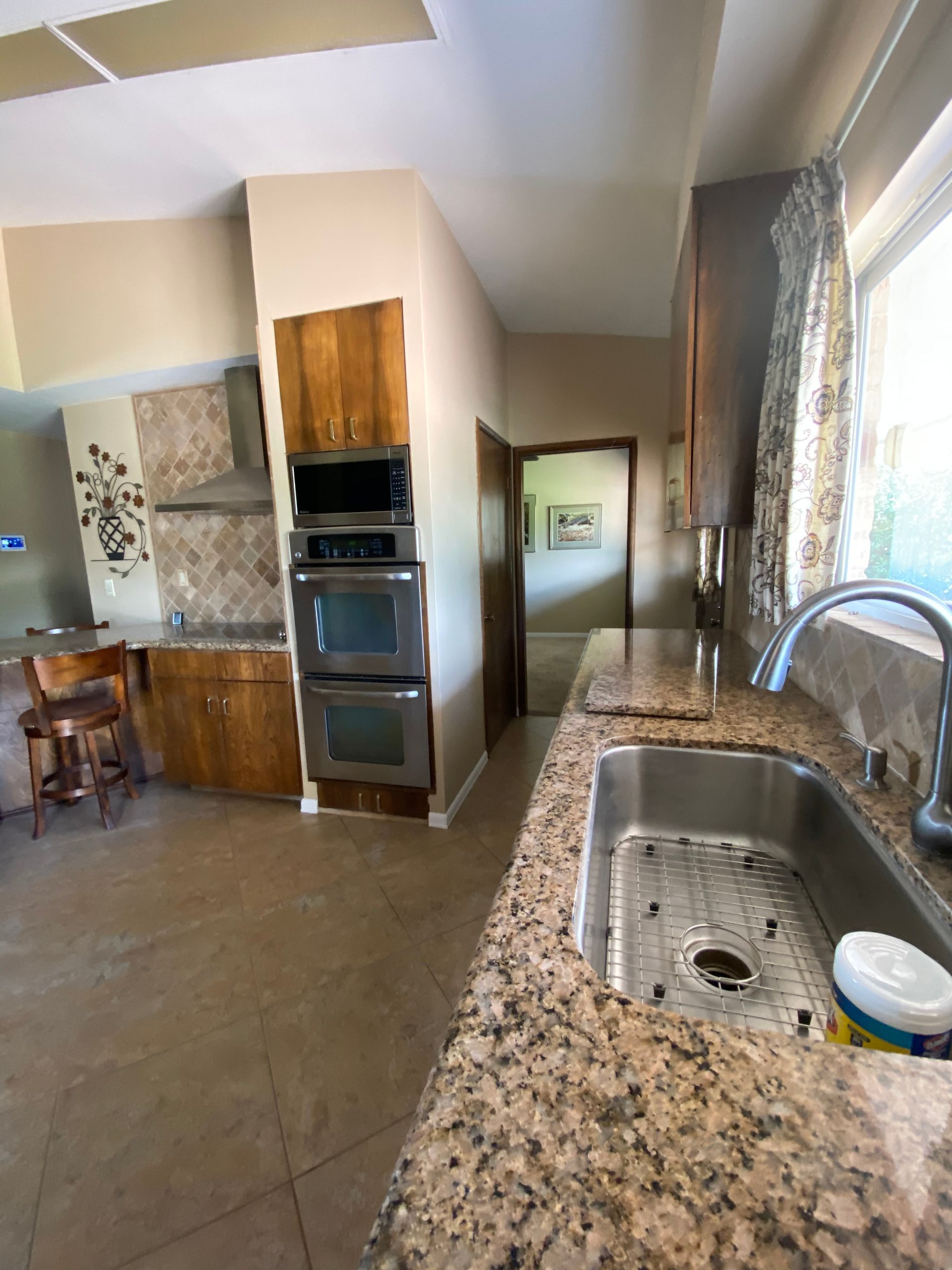 A kitchen with granite counter tops and a stainless steel sink
