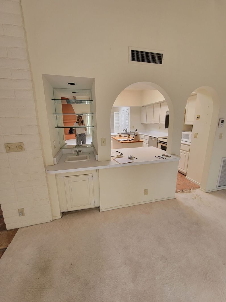 A living room with a view of a kitchen through an archway.