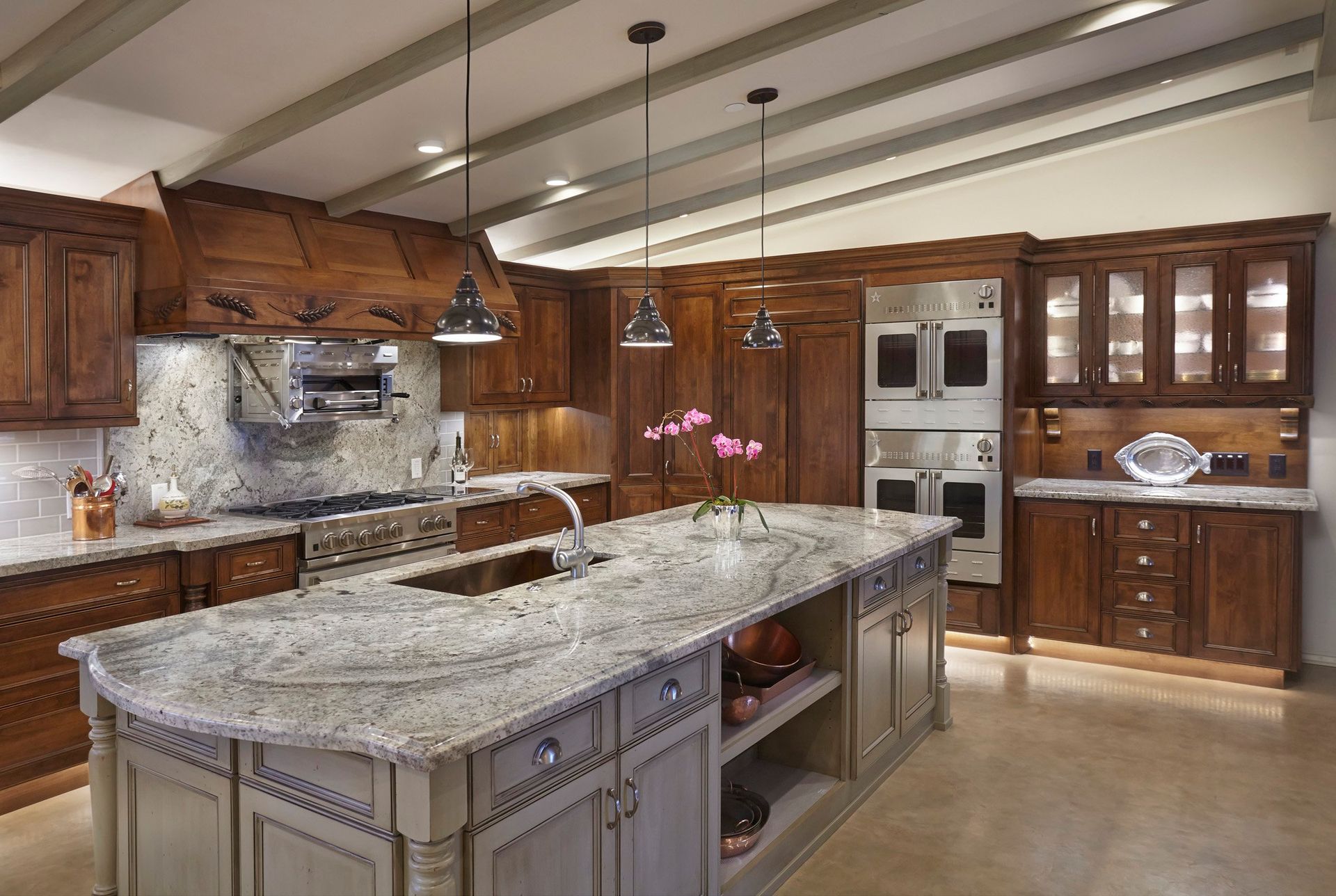 Luxurious kitchen with wood cabinetry, granite countertops, and island.
