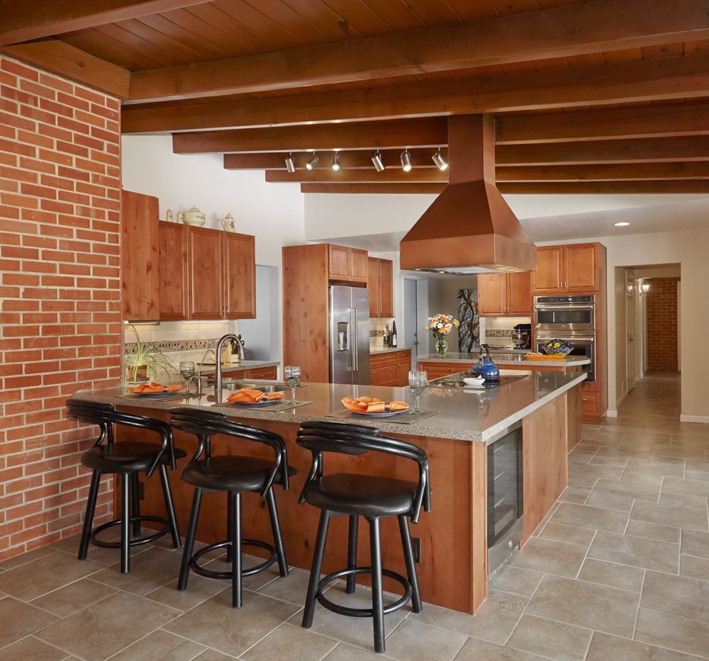 A kitchen with a large island and stools