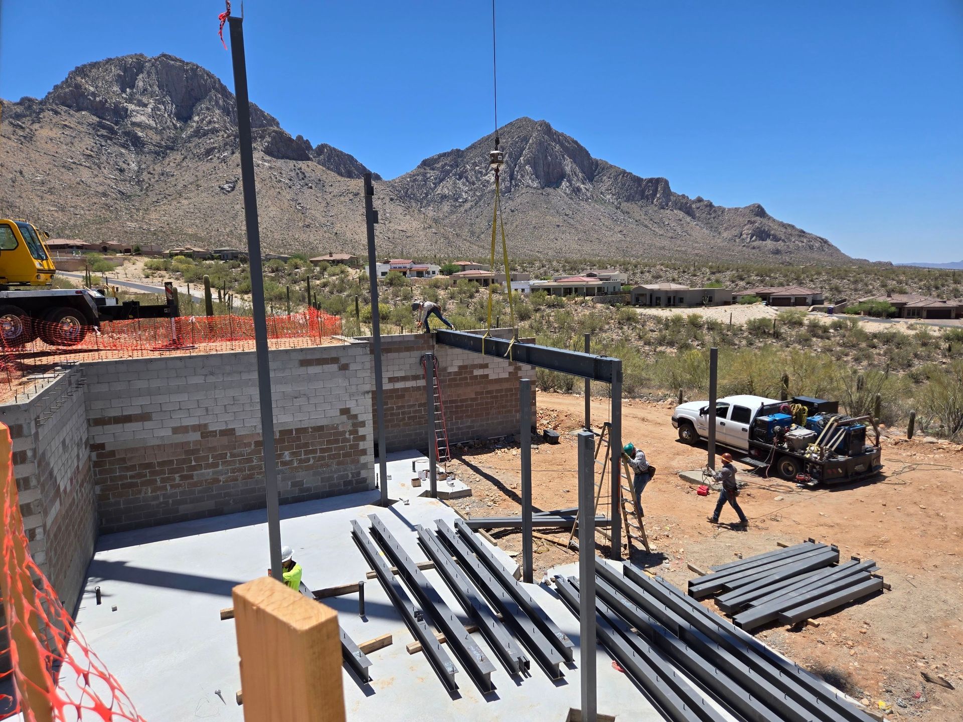 A construction site in the desert with mountains in the background