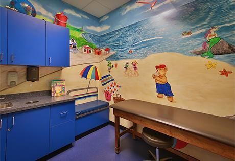 A doctor 's office with a painting of a beach on the wall.