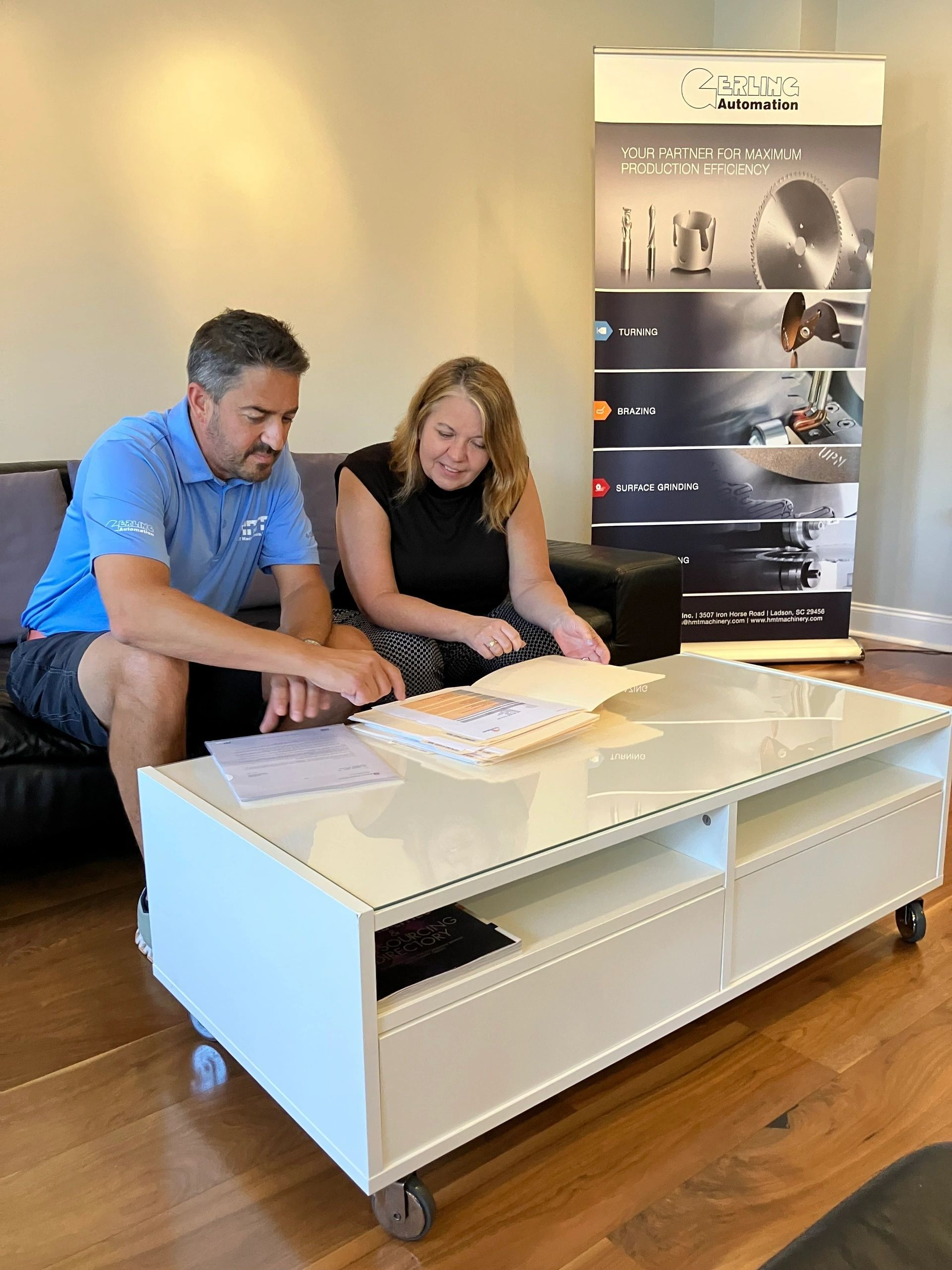 Two people reviewing financial data with a calculator, laptop, and charts.