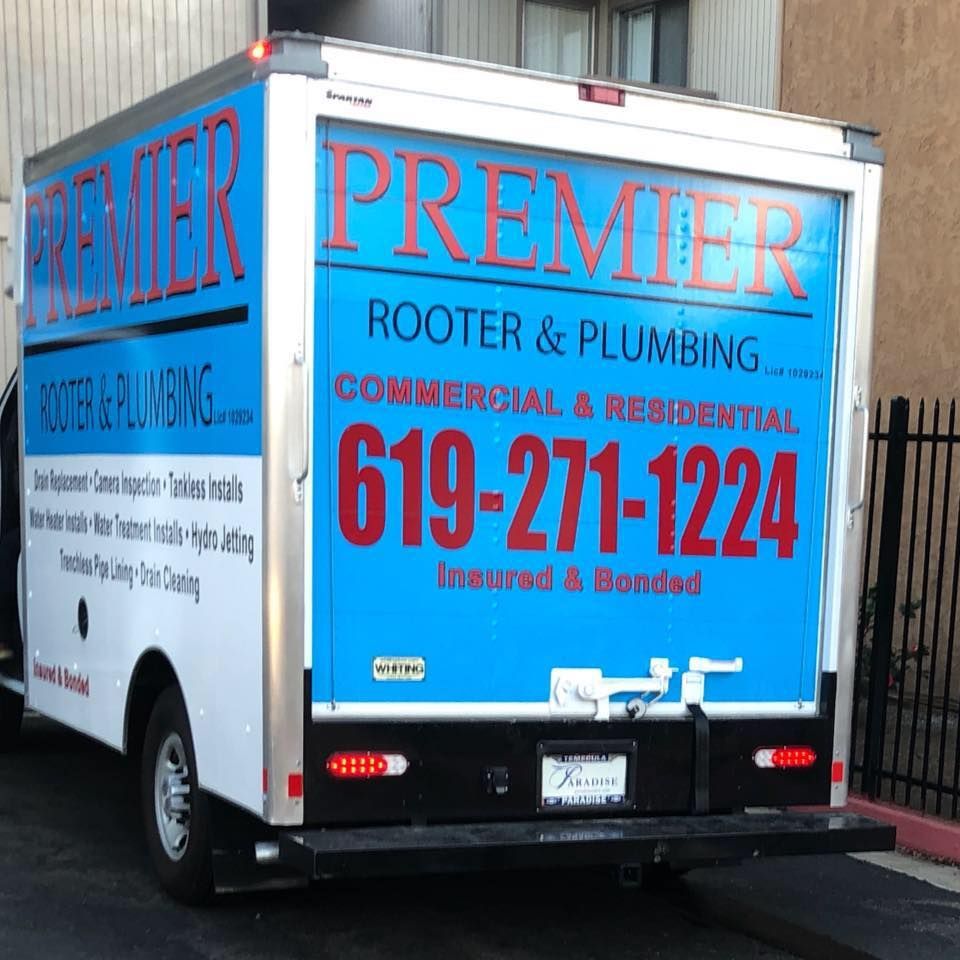 Rear view of Premier Rooter & Plumbing truck with business information on the back. Blue and red text on a white background.