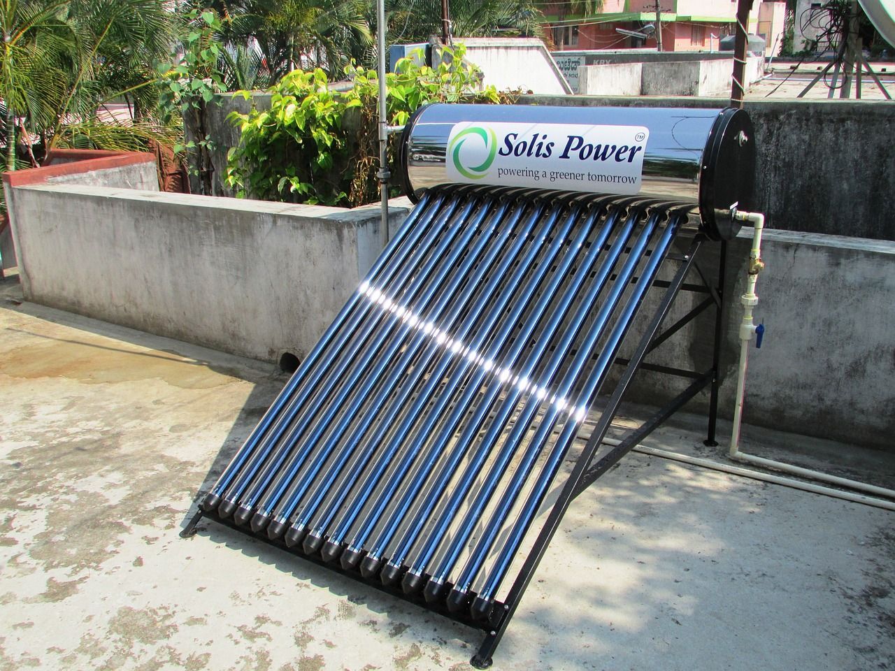 Solar water heater on a rooftop, with multiple dark tubes and a silver tank.