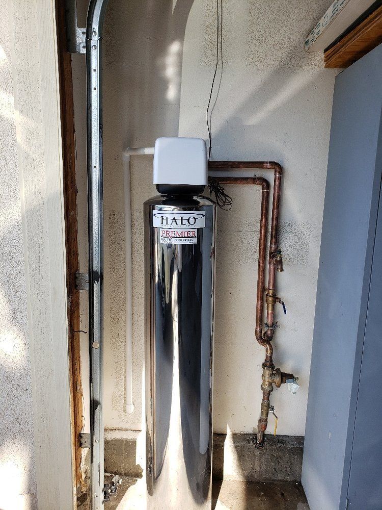 A water filtration system with copper pipes installed outside of a building.