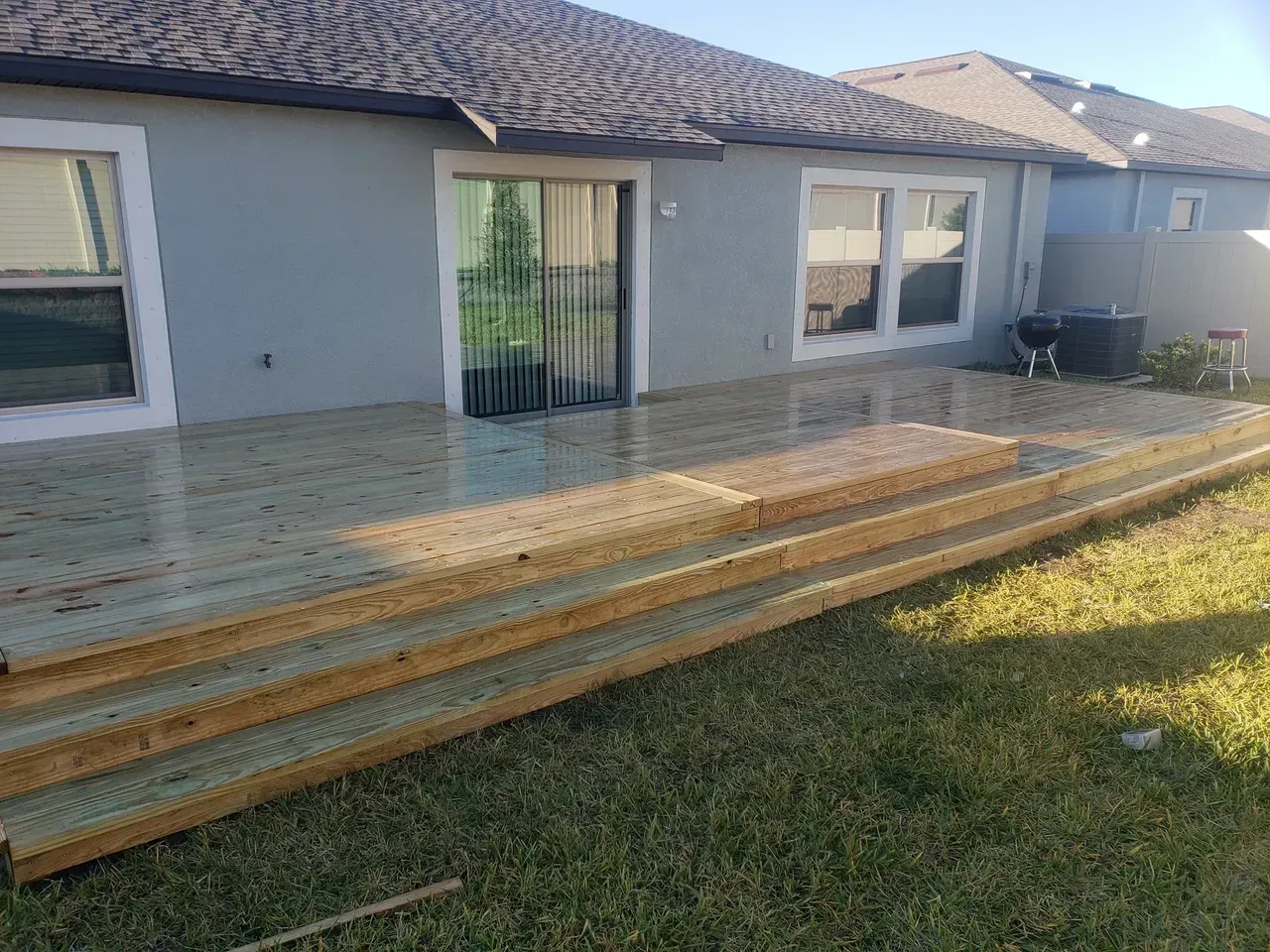 A house with a wooden deck and stairs in front of it.