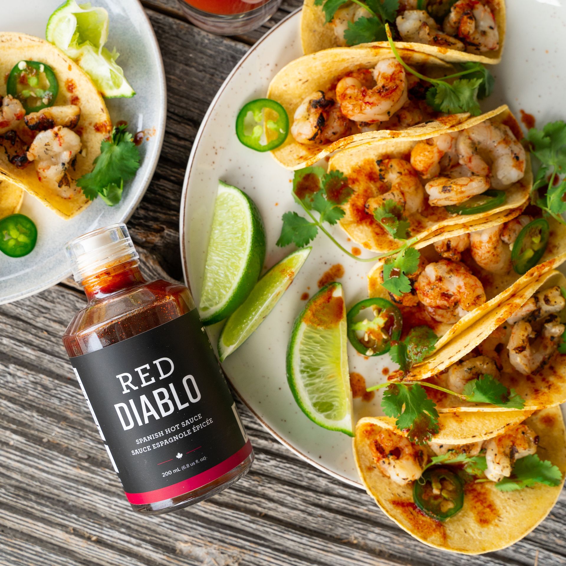 A bottle of red diablo is next to a plate of tacos