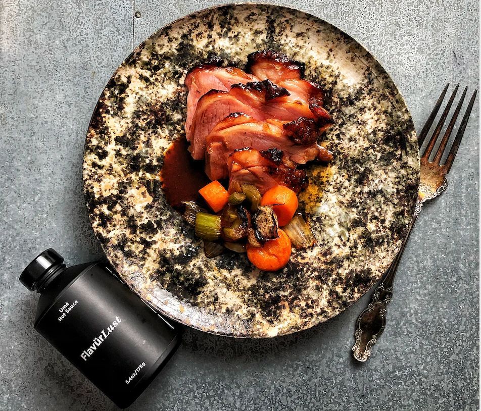 A plate of food next to a bottle that says roasted duck