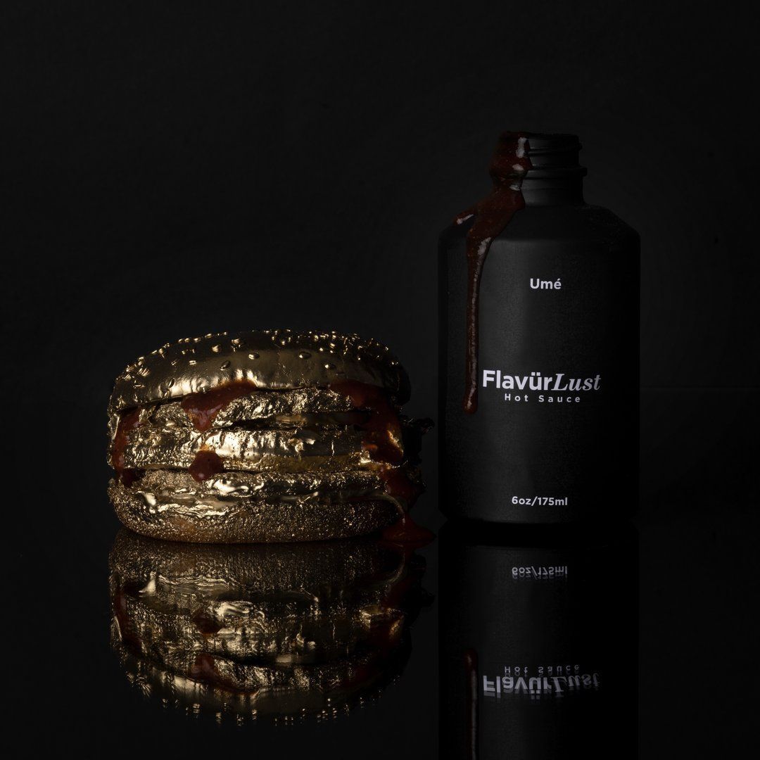A bottle of flavor lust sits next to a gold hamburger