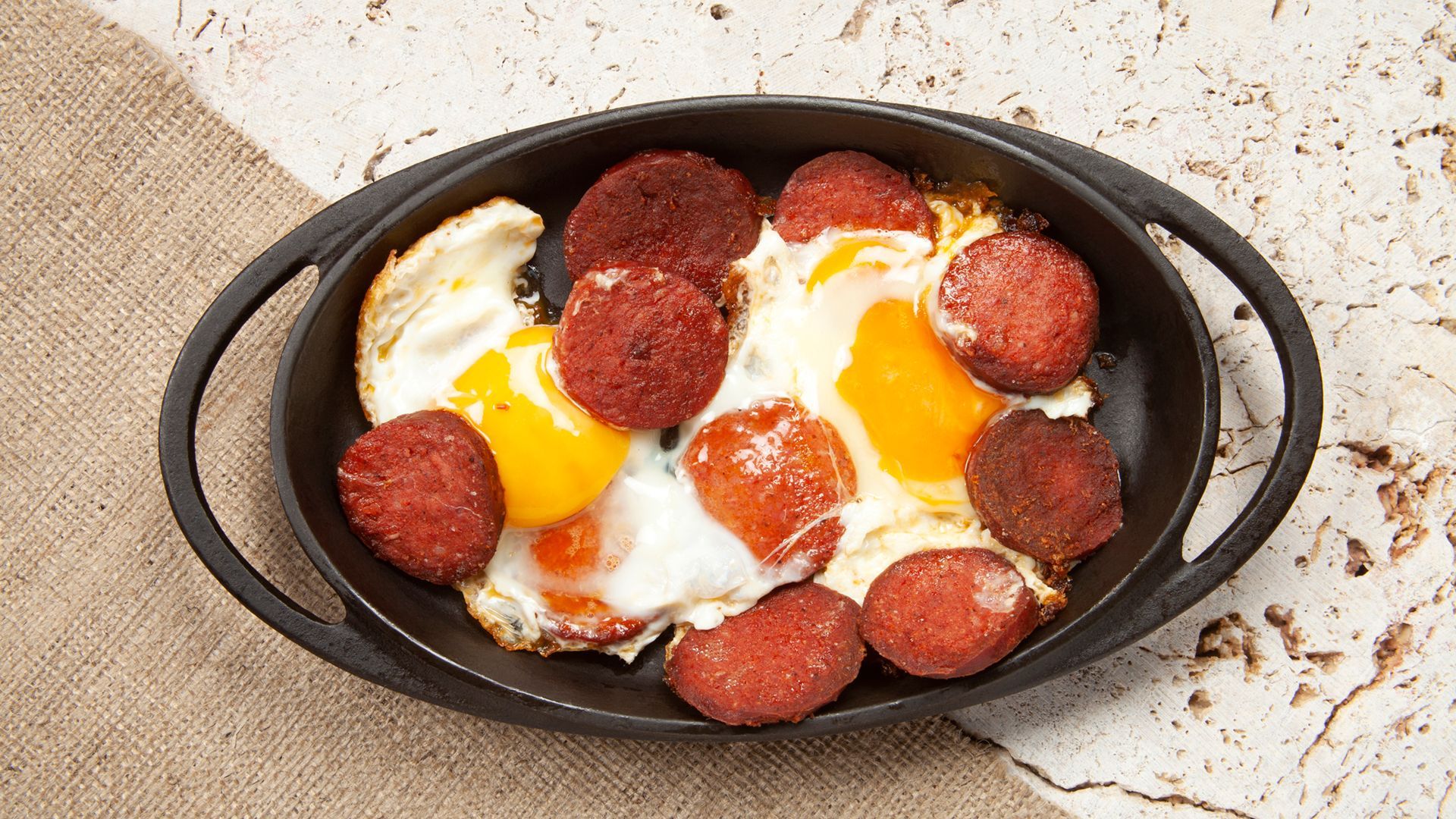 A skillet filled with pepperoni and eggs on a table