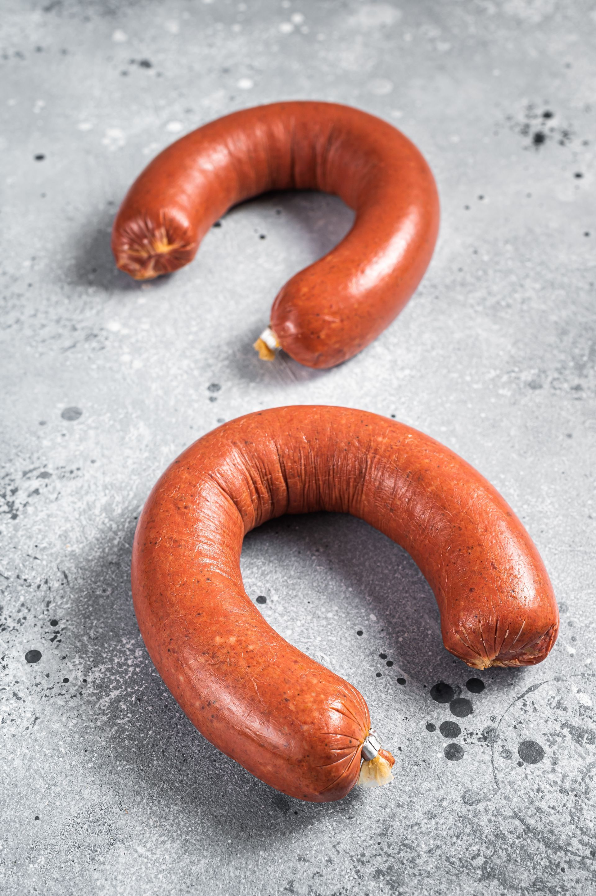 Two sausages shaped like a horseshoe are on a table.