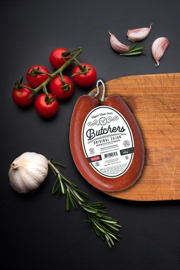 A piece of butchers sausage on a wooden cutting board