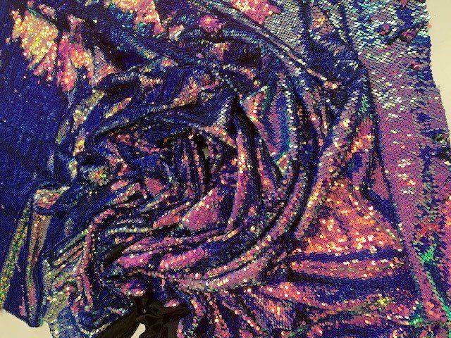 Primo piano di un pezzo di tessuto con paillettes blu e viola.