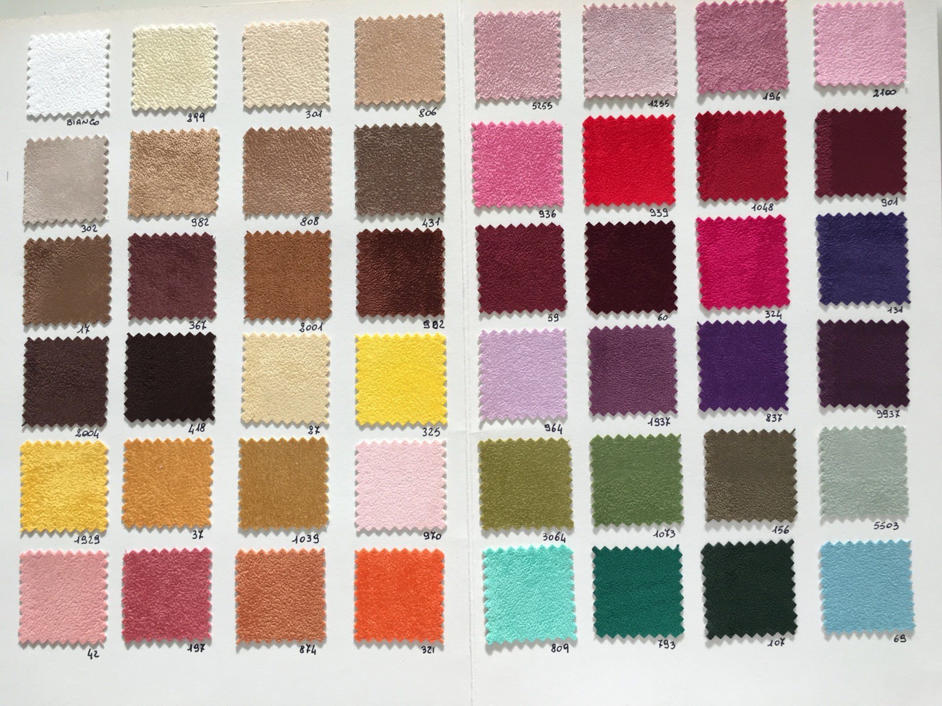 Un foglio di campioni di tessuto con molti colori diversi