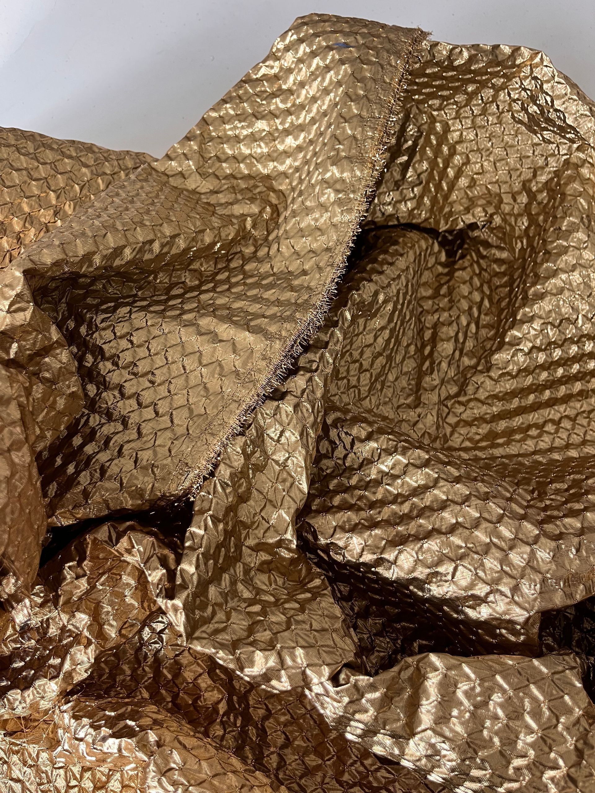 Primo piano di un pezzo di carta da regalo dorata su un tavolo.