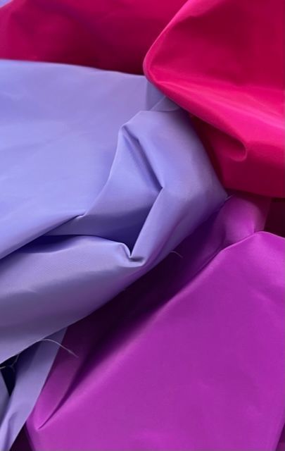 Un primo piano di tre tessuti di colore diverso impilati uno sopra l'altro.