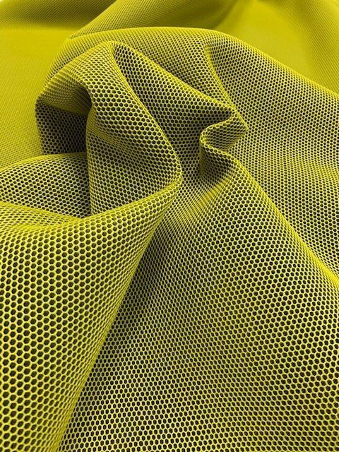Primo piano di un pezzo di tessuto a rete giallo.