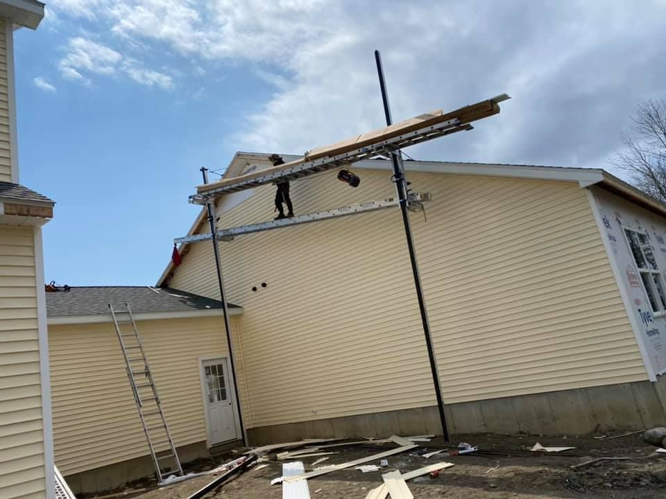 A man is working on the roof of a house.