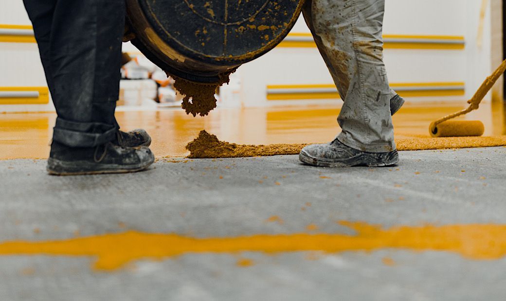 workers pouring polyurethane gloss on garage floor