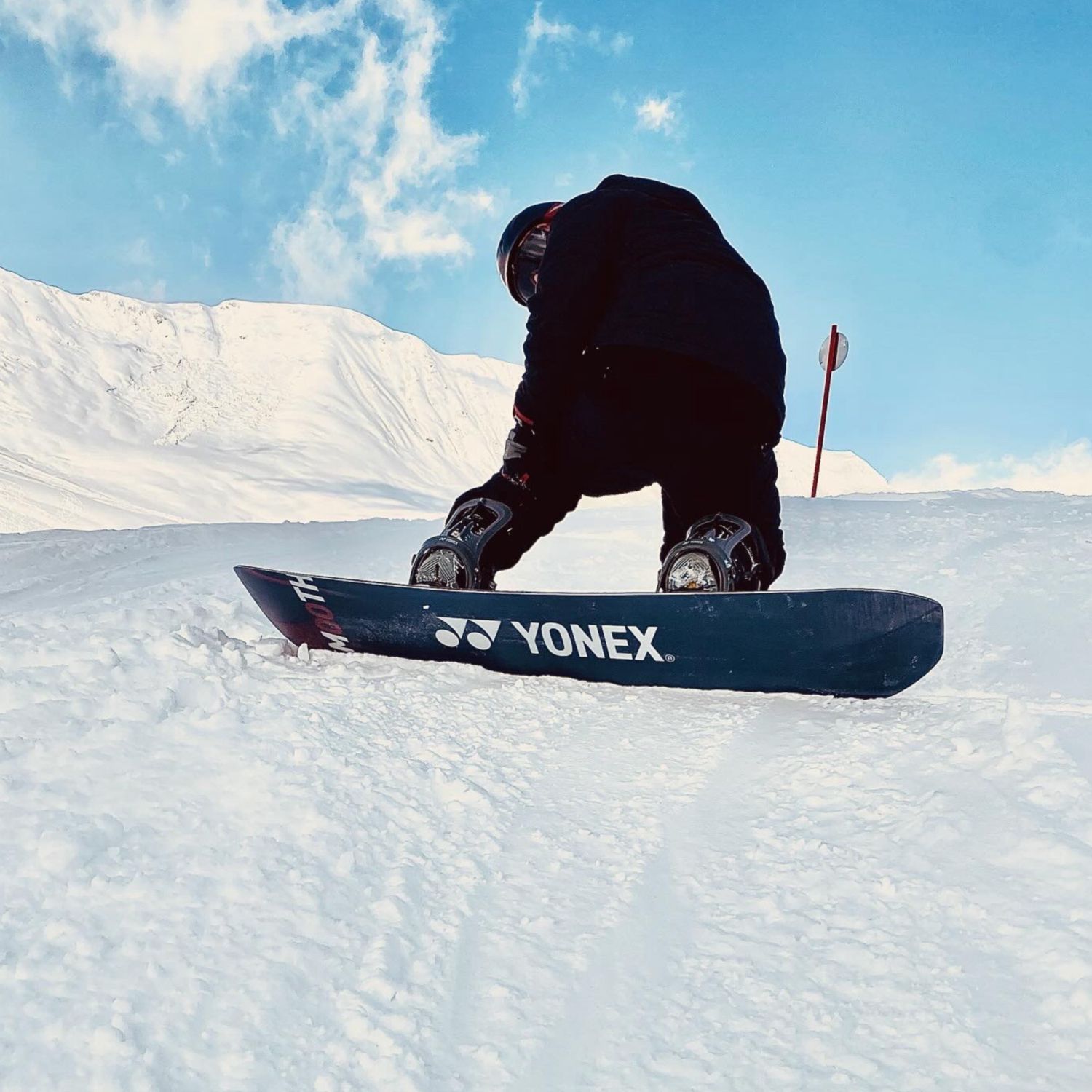 Eine Person auf einem Snowboard mit der Aufschrift Yonex