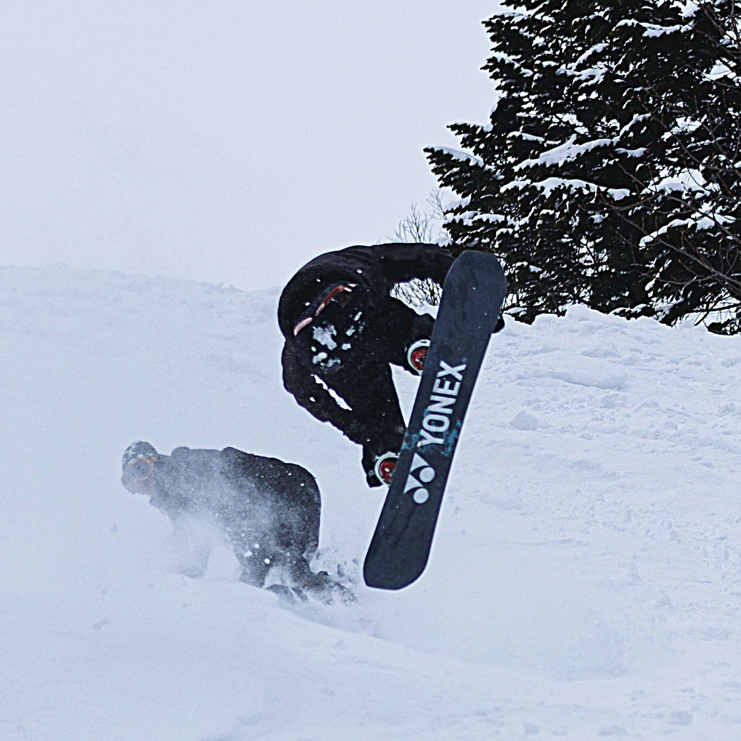 Ein Snowboarder macht einen Trick auf einem Yonex-Board