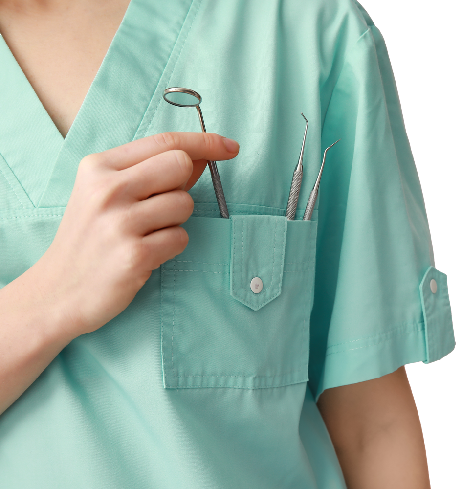 A woman in a green scrub top is holding dental tools in her pocket