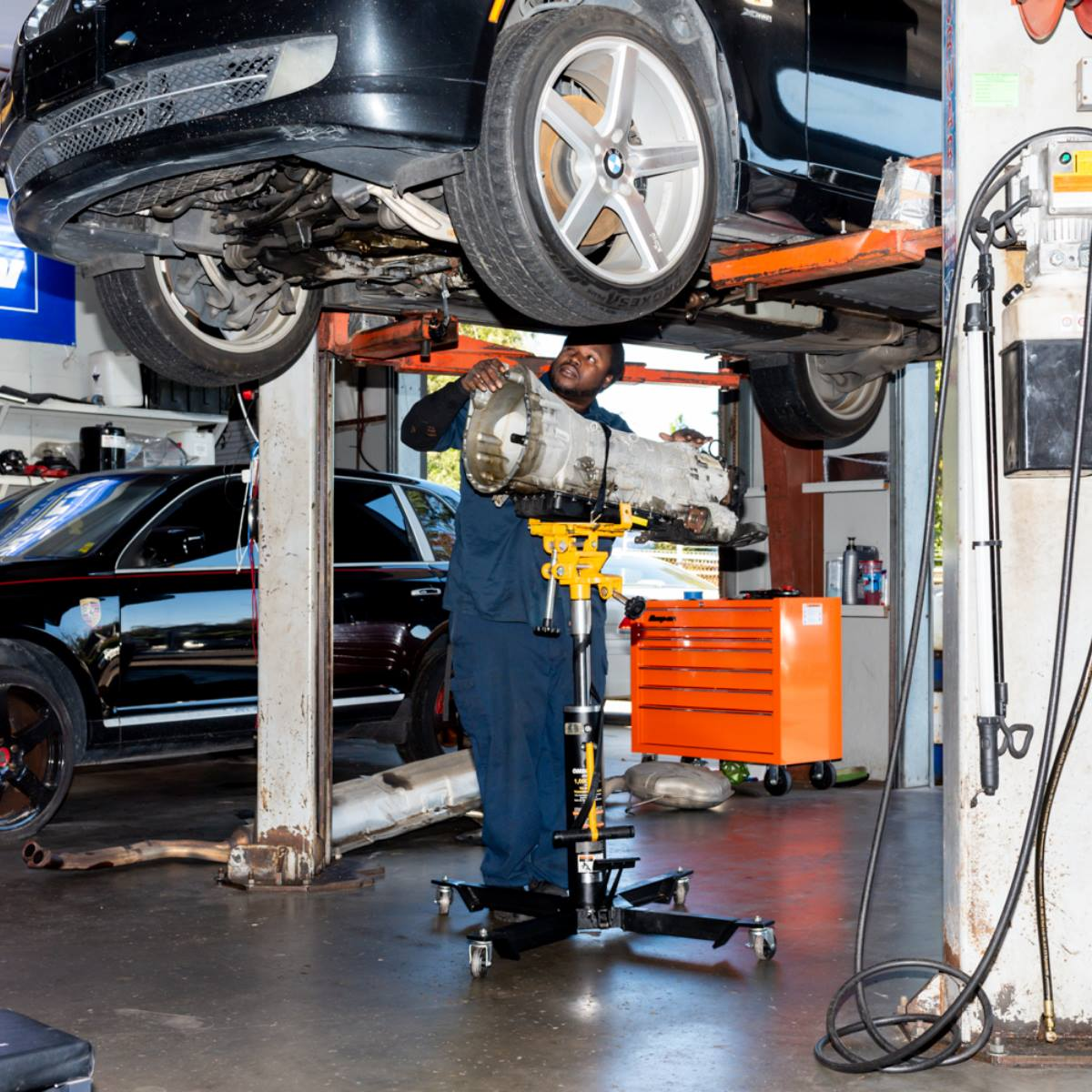 Mechanic removing a transmission from a car | Randall's Autohaus