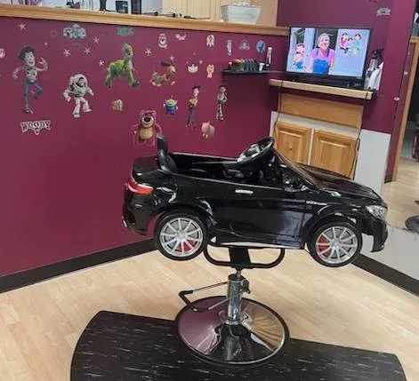 A child 's barber chair in the shape of a car.