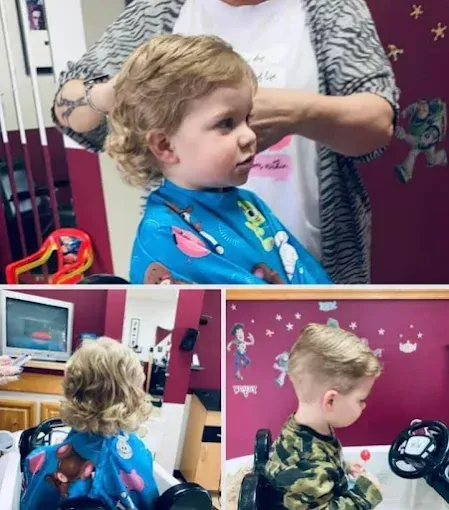 A little boy is getting his hair cut by a woman