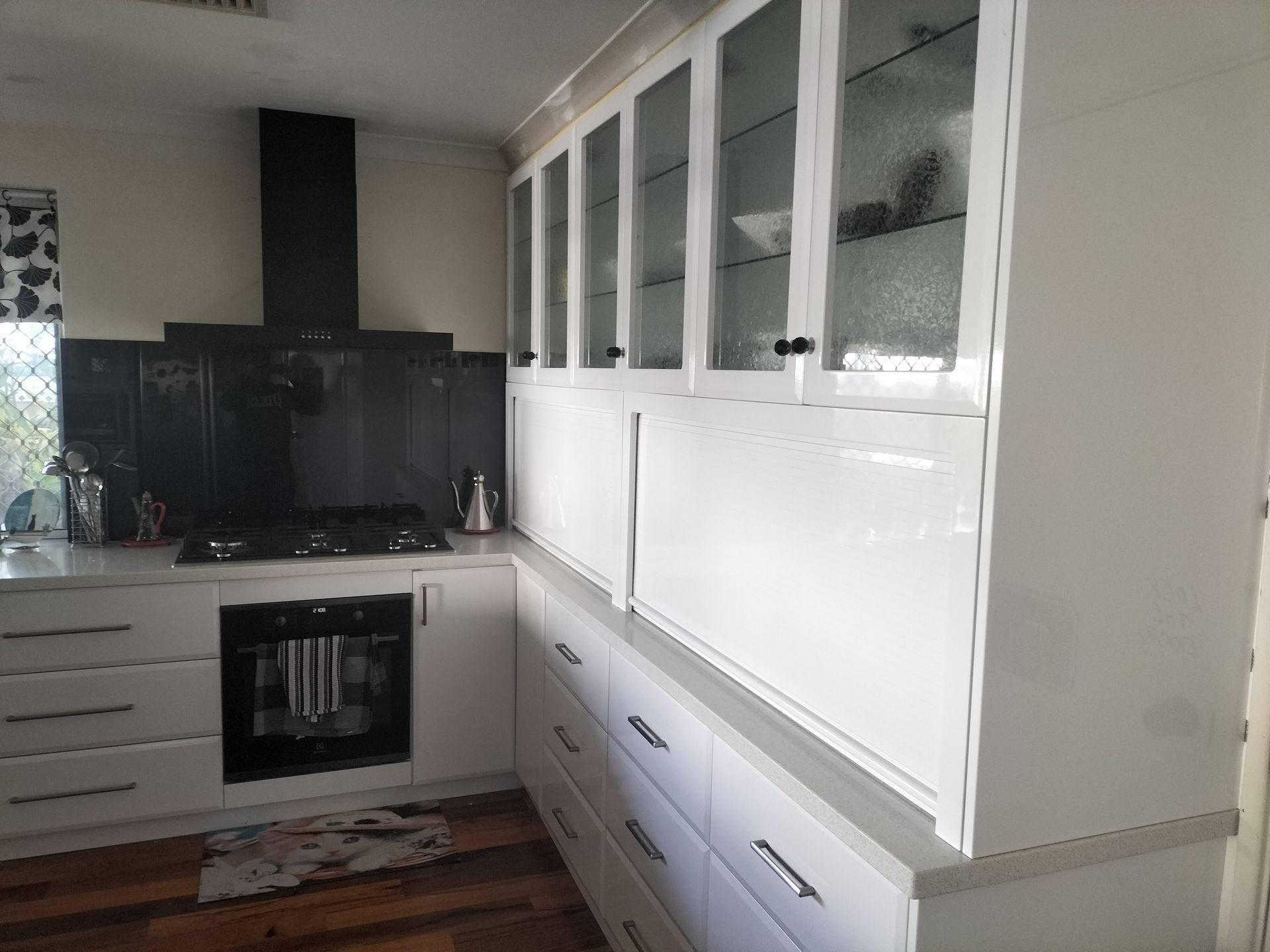 White kitchen cabinets, black backsplash and range hood.