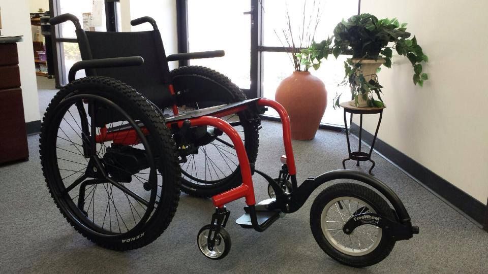 A wheelchair is sitting in a room next to a potted plant