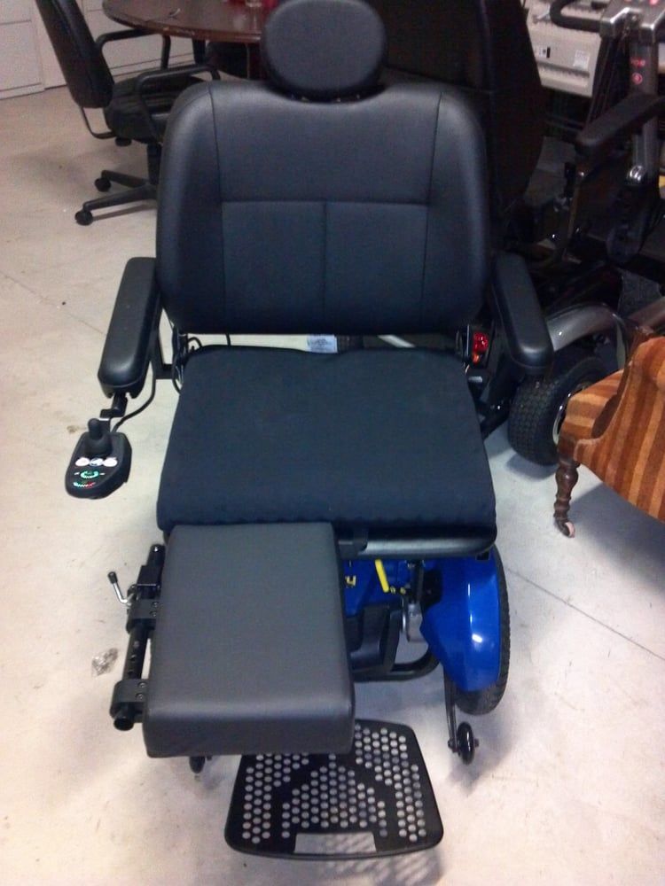 A black chair with a blue scooter in the background