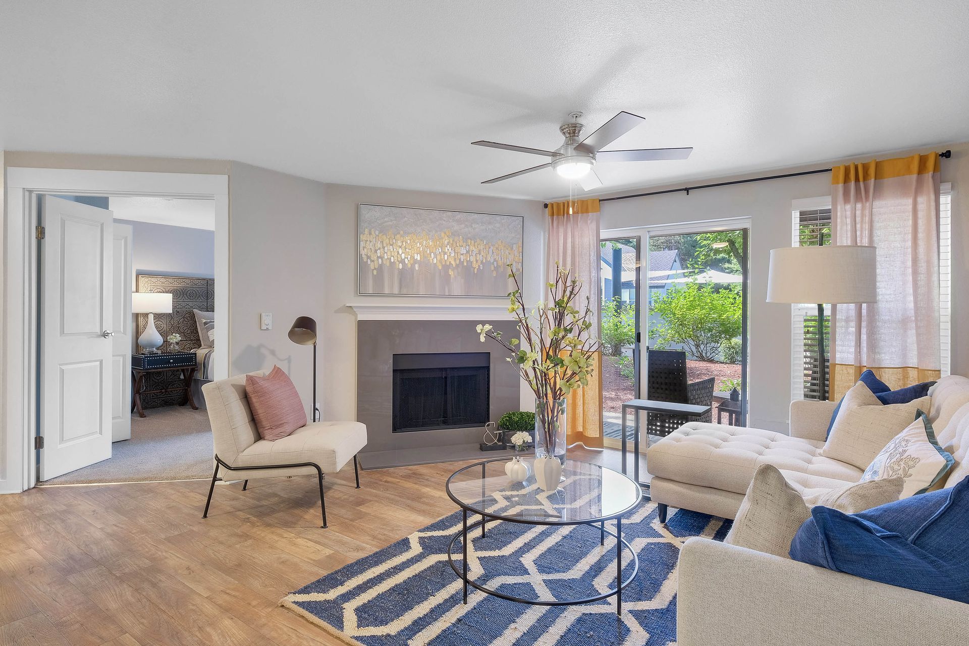 Living room in an apartment with a fireplace, seating area, and sliding glass doors to the patio.