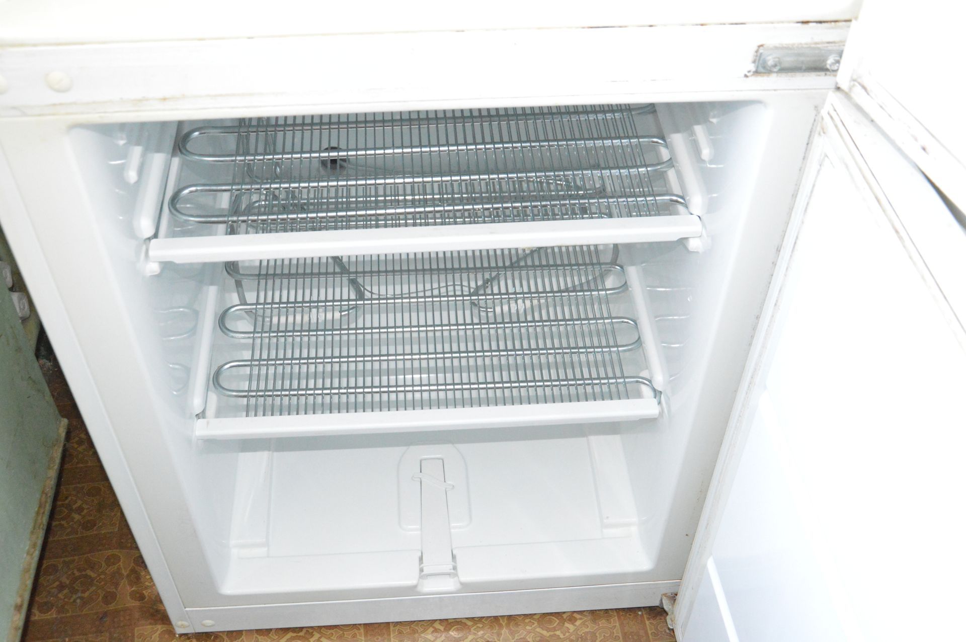 The inside of an empty refrigerator with the door open.