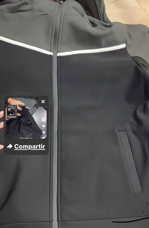 Una persona está tomando una fotografía de una chaqueta negra con un teléfono celular.