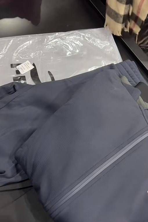 Un par de pantalones y una chaqueta están uno encima del otro sobre una mesa.