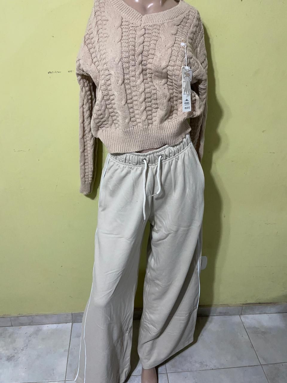 Un maniquí lleva un suéter y pantalones anchos.