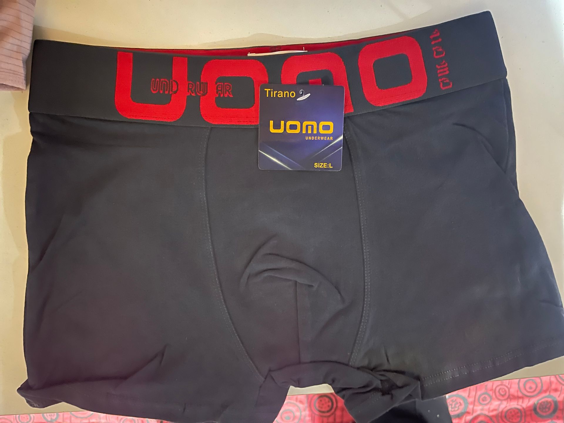 Un par de calzoncillos bóxer negros con la palabra "uomo" en la cinturilla.