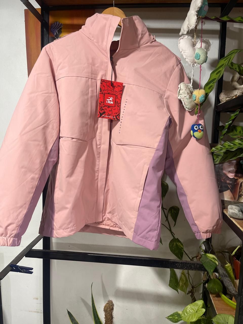 Una chaqueta rosa y morada está colgada en una percha.
