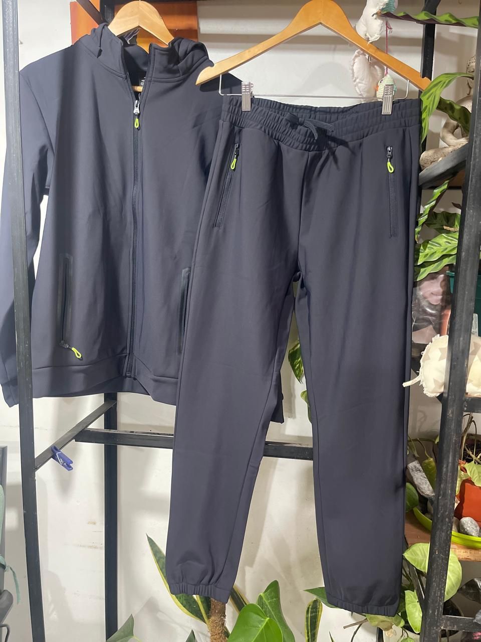 Una chaqueta negra y unos pantalones están colgados en un perchero.