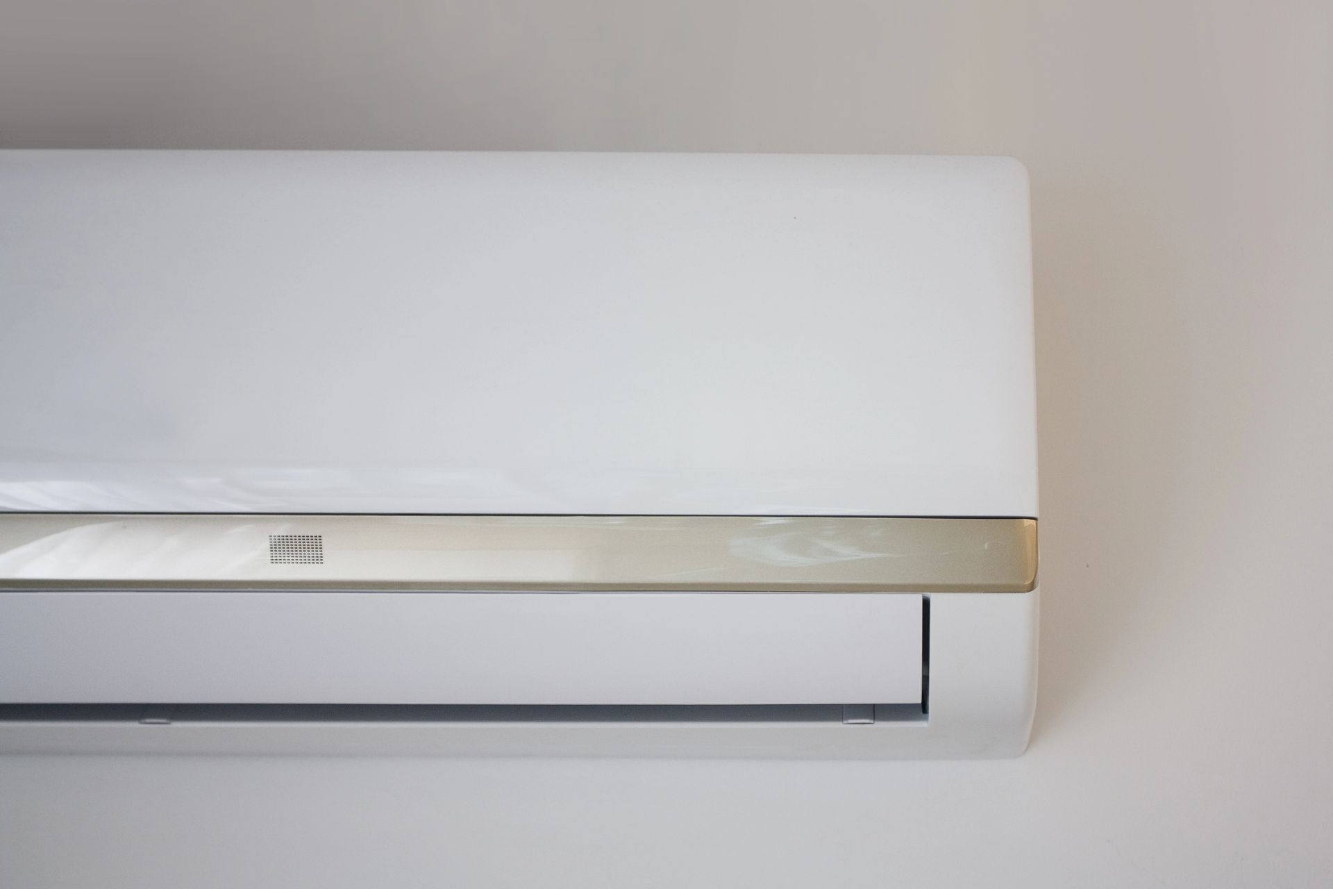 Condizionatore d'aria bianco a parete su una parete beige