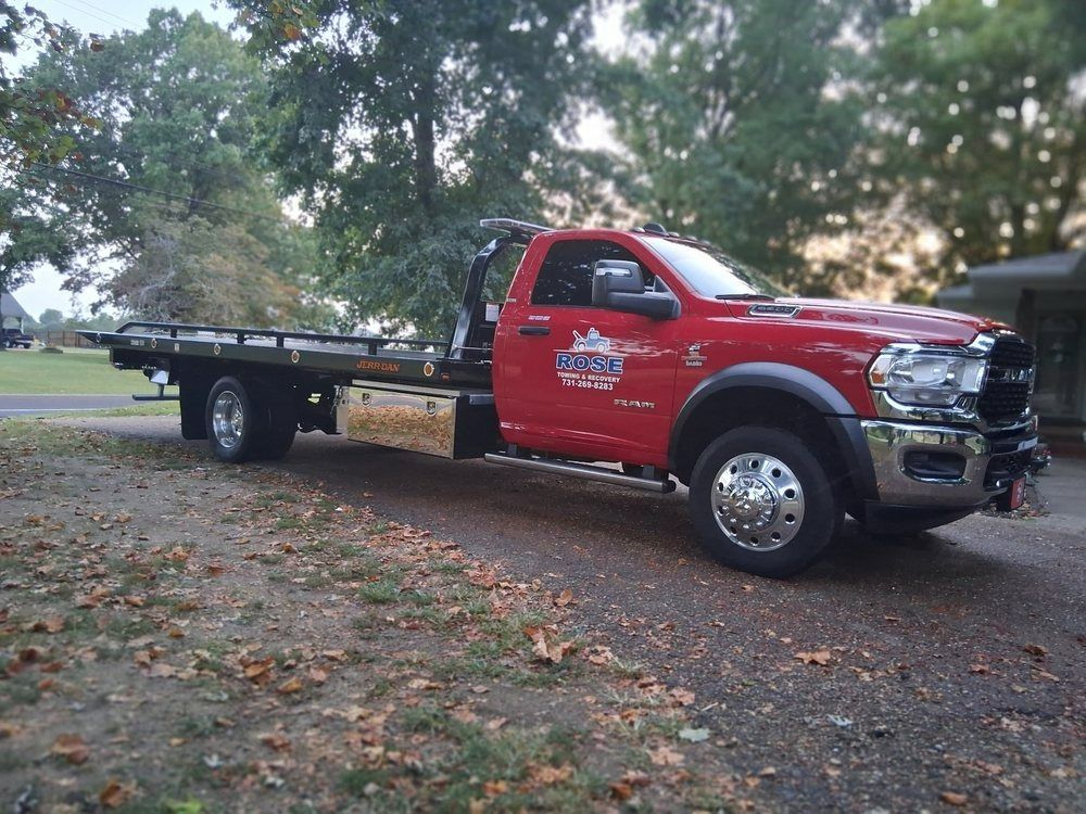 Woman in straw hat smiles, holding wine glass near a lake.
